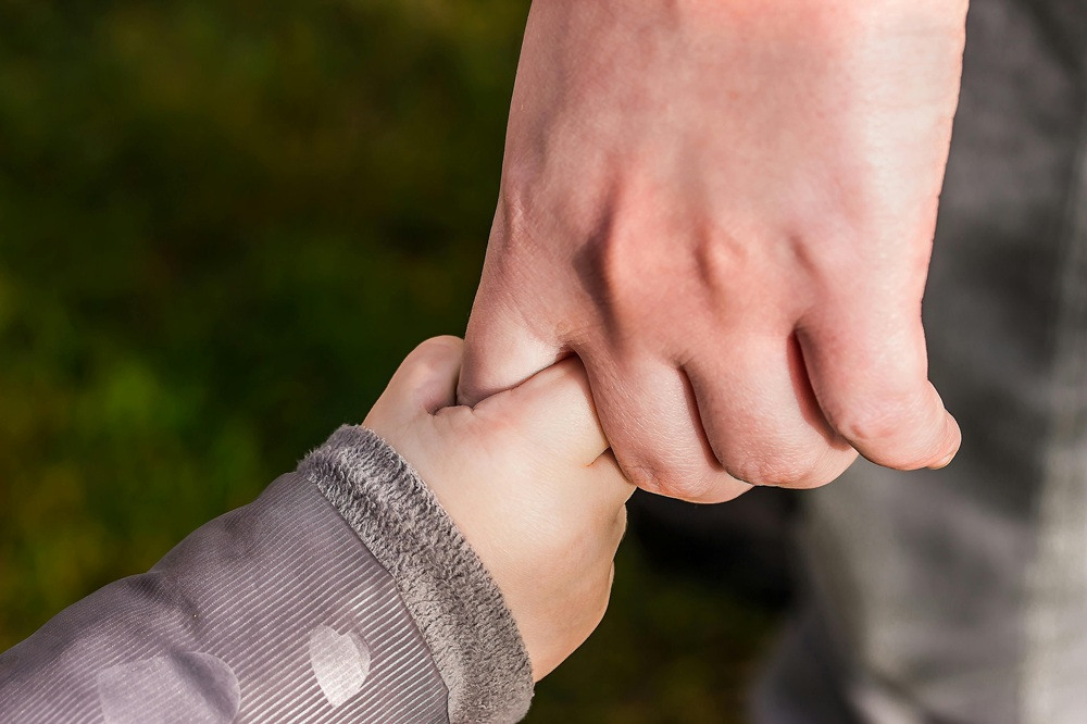Childs hand holding an adults hand